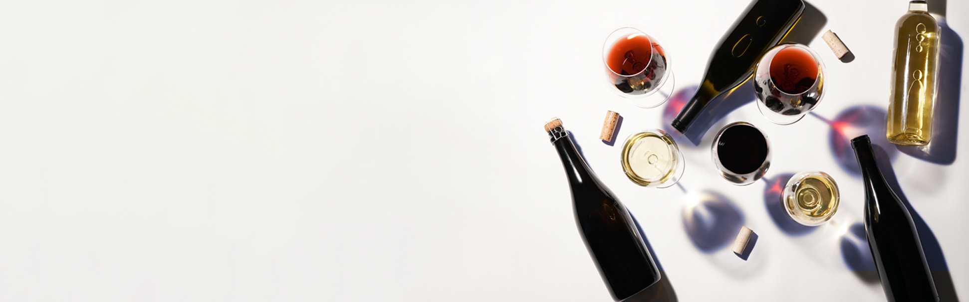 A group of bottles and glasses on a table, representing the wide variety of wines available.